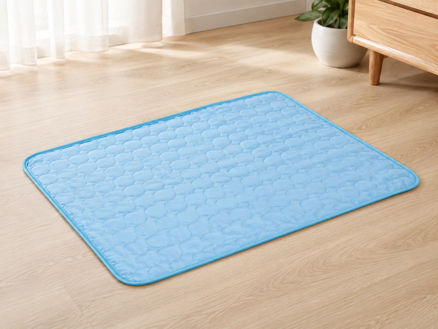 The blue Chilloof cooling mat lying flat on a hardwood floor